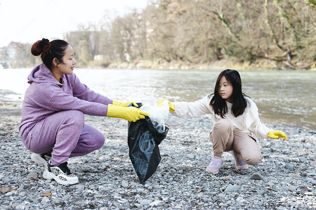 Conceito do dia da terra mulher e filha recolhem lixo em sacos de lixo IA