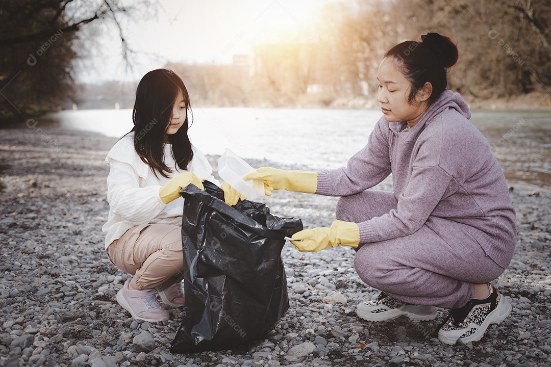 Conceito do dia da terra mulher e filha recolhem lixo em sacos de lixo IA