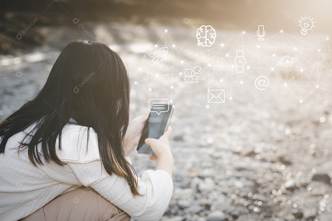 Pequena estudante asiática usando smartphone entre em contato conosco com tela digital com o gráfico Ícones IA