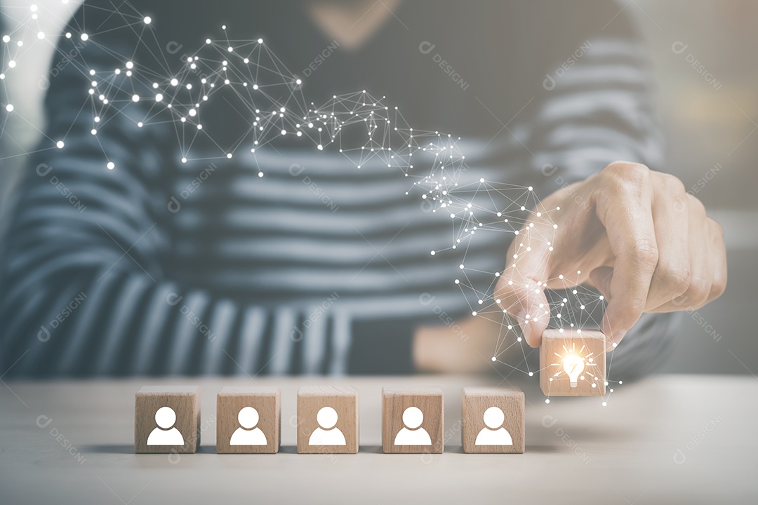 Mão de empresário segurando ícone de lâmpada com ícone de negócios em cubo de madeira e trabalhando na mesa IA