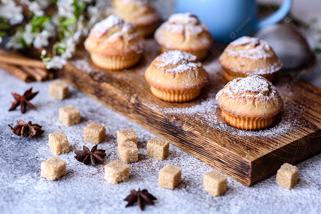 Cupcakes fresquinhos de farinha de arroz com banana e baunilha com uma caneca de chocolate quente.