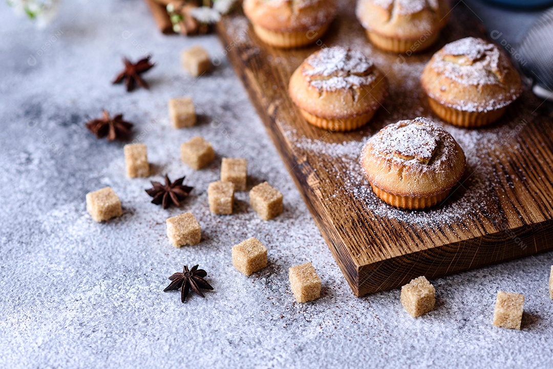Cupcakes fresquinhos de farinha de arroz com banana e baunilha com uma caneca de chocolate quente.