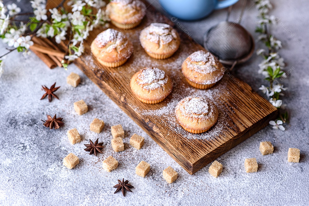 Cupcakes fresquinhos de farinha de arroz com banana e baunilha com uma caneca de chocolate quente.