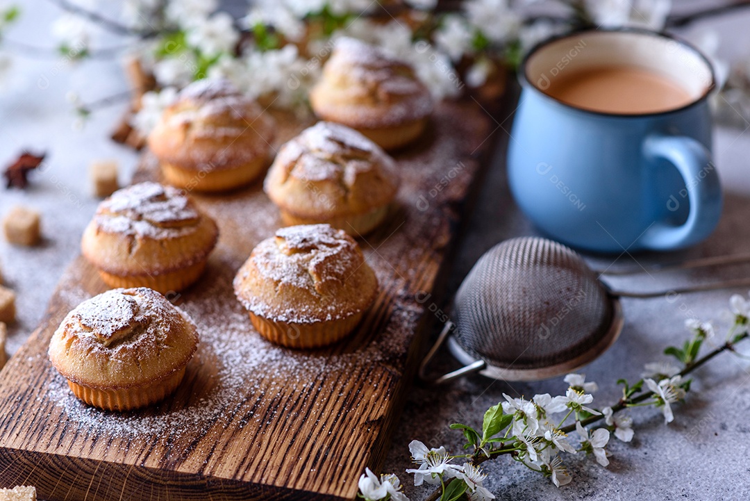 Cupcakes fresquinhos de farinha de arroz com banana e baunilha com uma caneca de chocolate quente.