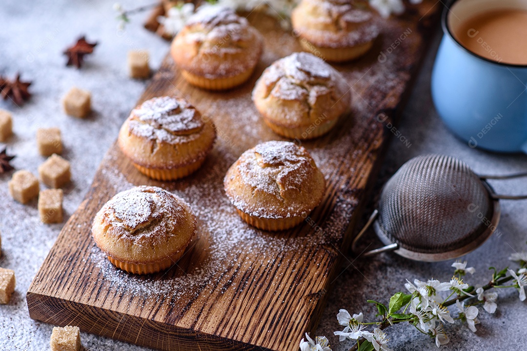 Cupcakes fresquinhos de farinha de arroz com banana e baunilha com uma caneca de chocolate quente.