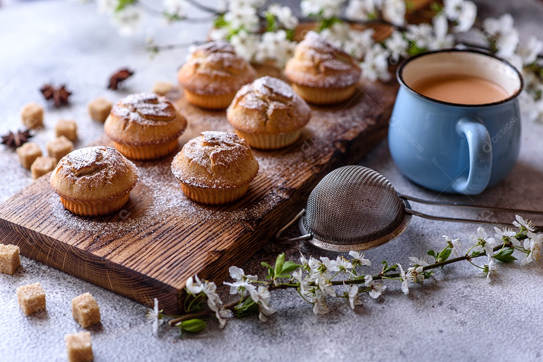 Cupcakes fresquinhos de farinha de arroz com banana e baunilha com uma caneca de chocolate quente.