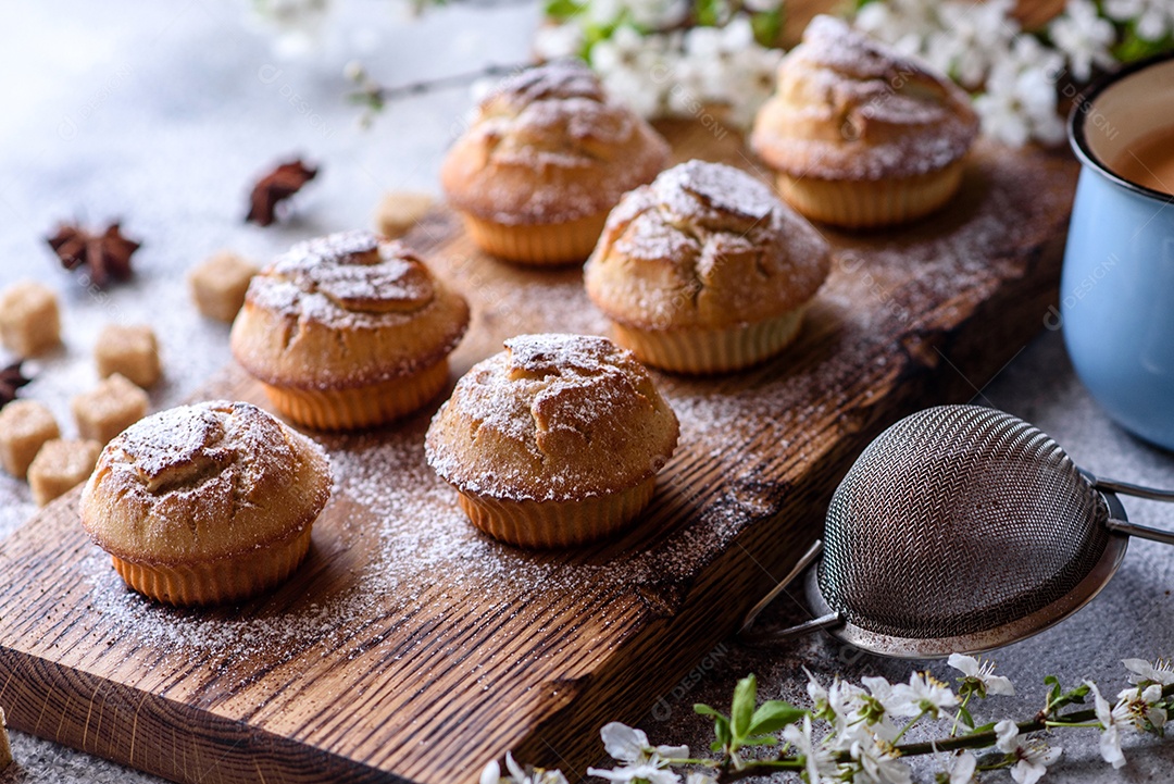 Cupcakes fresquinhos de farinha de arroz com banana e baunilha com uma caneca de chocolate quente.
