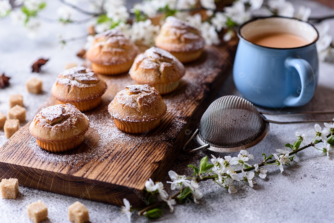 Cupcakes fresquinhos de farinha de arroz com banana e baunilha com uma caneca de chocolate quente.