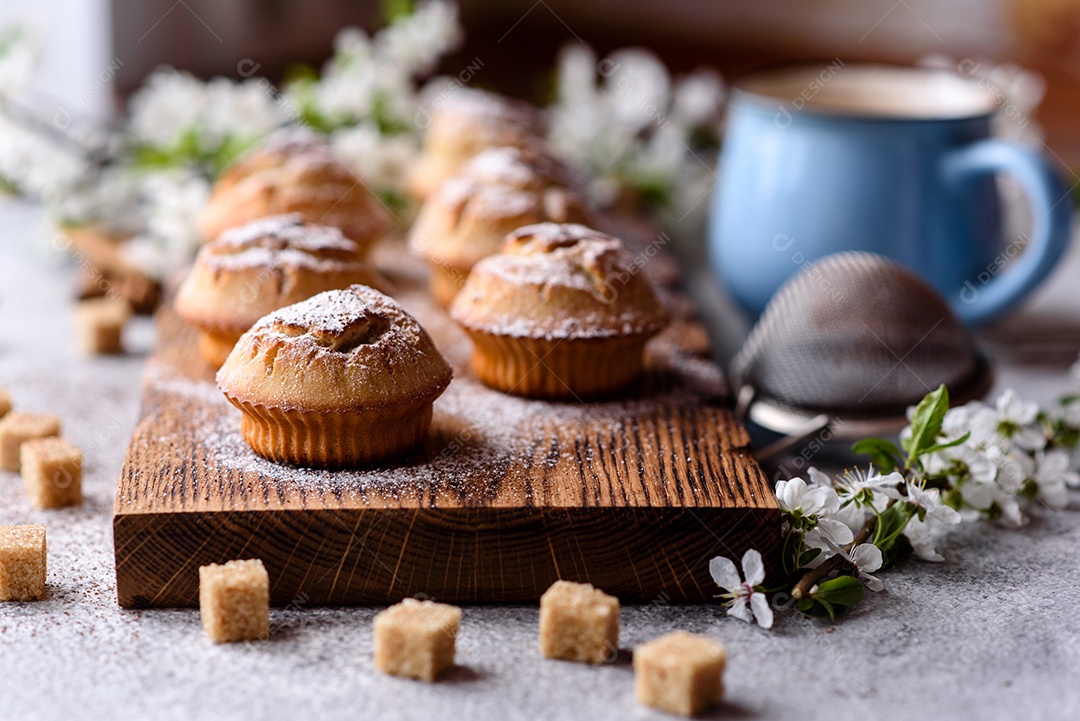 Cupcakes fresquinhos de farinha de arroz com banana e baunilha com uma caneca de chocolate quente.