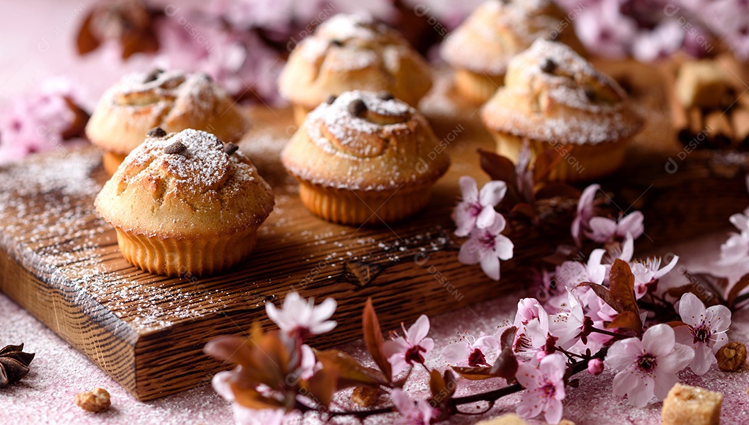 Cupcakes fresquinhos de farinha de arroz com banana e baunilha com uma caneca de chocolate quente.
