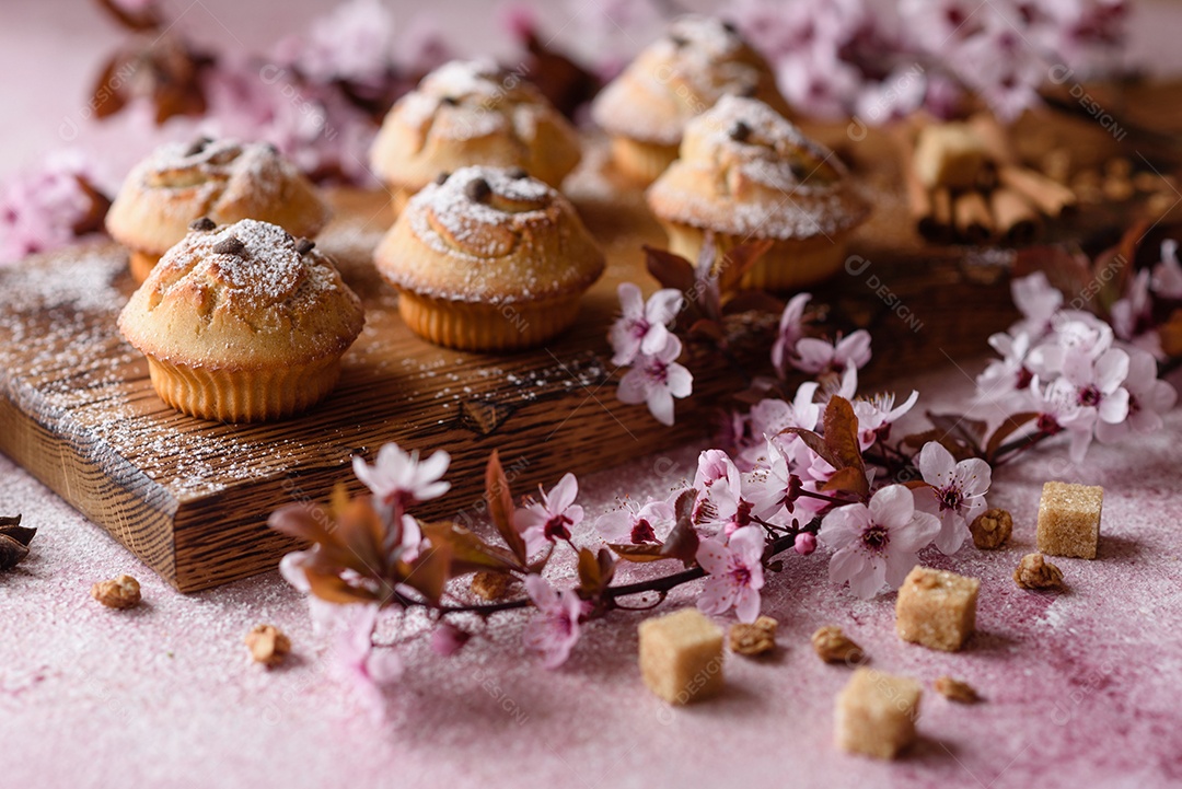 Cupcakes fresquinhos de farinha de arroz com banana e baunilha com uma caneca de chocolate quente.