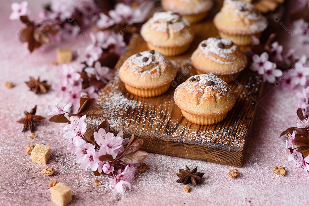 Cupcakes fresquinhos de farinha de arroz com banana e baunilha com uma caneca de chocolate quente.