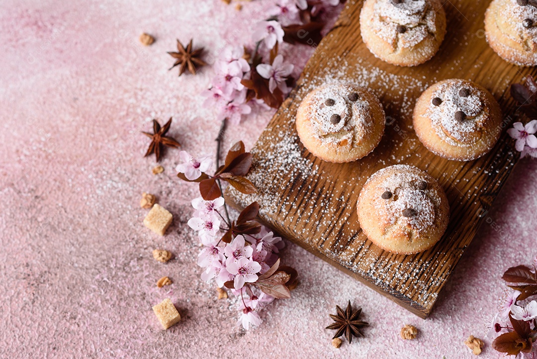 Cupcakes fresquinhos de farinha de arroz com banana e baunilha com uma caneca de chocolate quente.