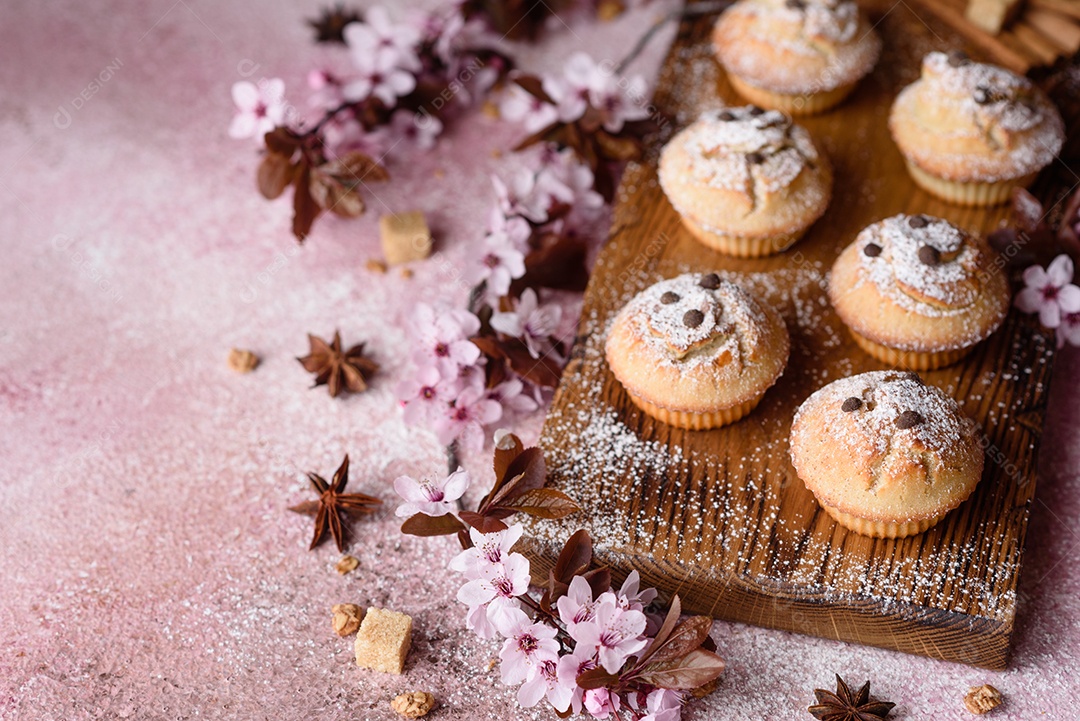 Cupcakes fresquinhos de farinha de arroz com banana e baunilha com uma caneca de chocolate quente.