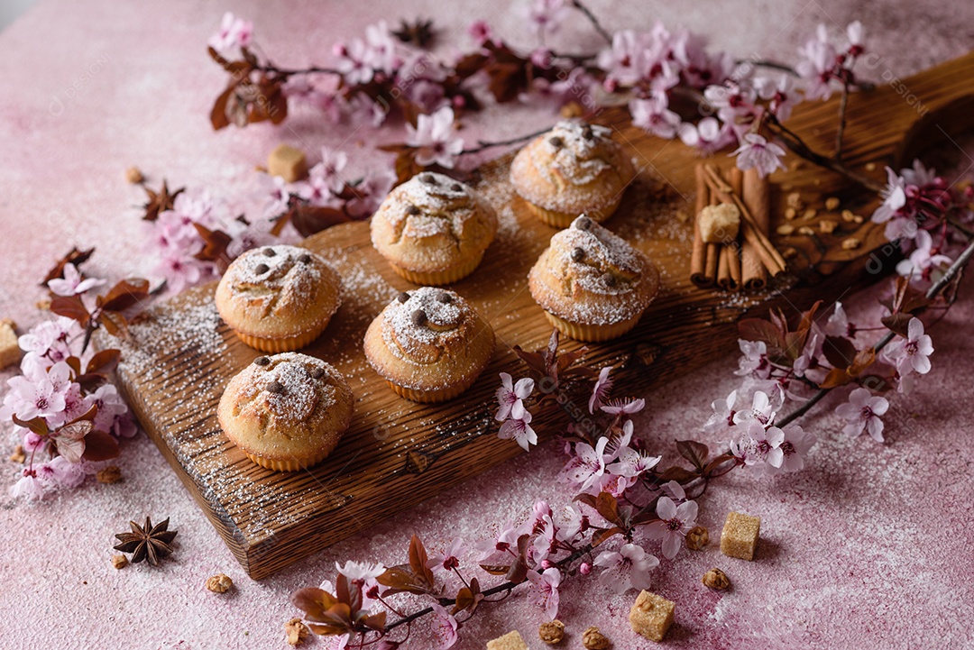 Cupcakes fresquinhos de farinha de arroz com banana e baunilha com uma caneca de chocolate quente.