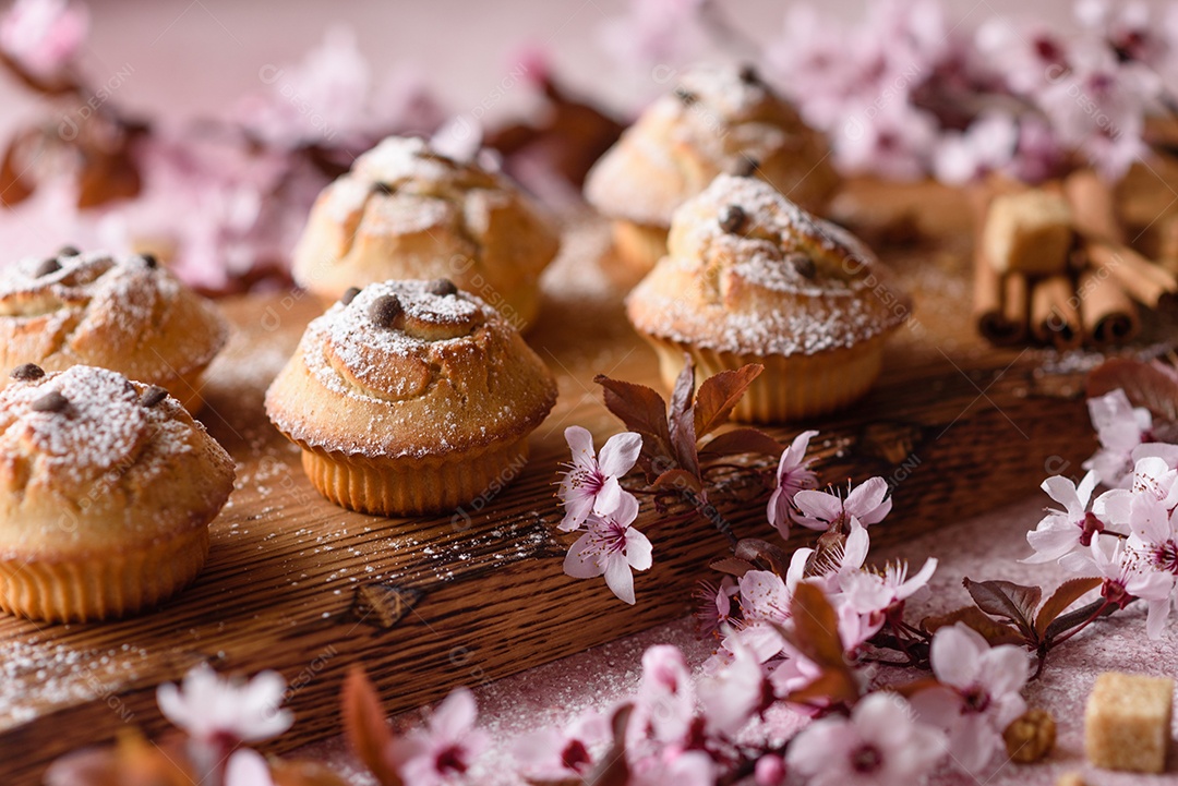 Cupcakes fresquinhos de farinha de arroz com banana e baunilha com uma caneca de chocolate quente.