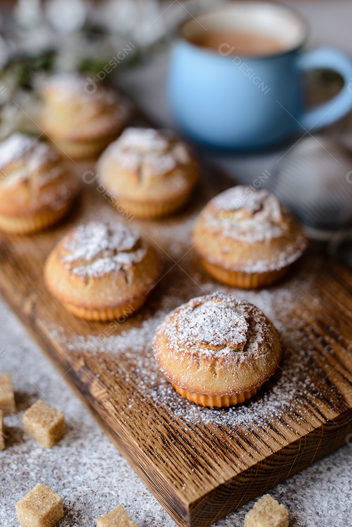 Cupcakes fresquinhos de farinha de arroz com banana e baunilha com uma caneca de chocolate quente.
