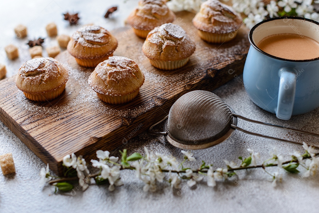 Cupcakes fresquinhos de farinha de arroz com banana e baunilha com uma caneca de chocolate quente.