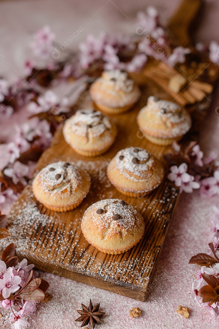 Cupcakes fresquinhos de farinha de arroz com banana e baunilha com uma caneca de chocolate quente.