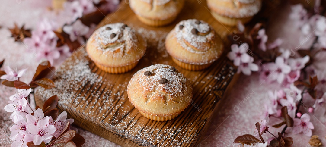 Cupcakes fresquinhos de farinha de arroz com banana e baunilha com uma caneca de chocolate quente.