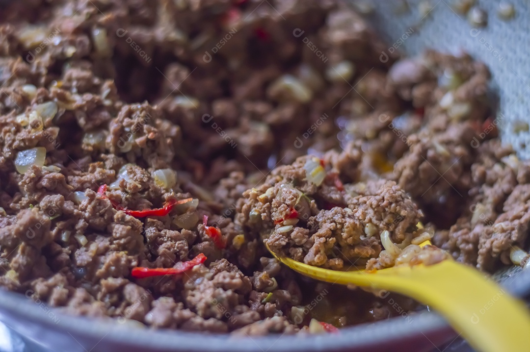 Carne moída pronta temperada com pimentão vermelho, textura de carne.