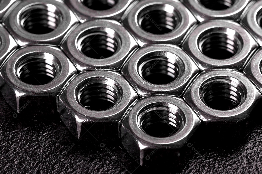 Porcas de aço metálicas colocadas em composição sobre um fundo preto
