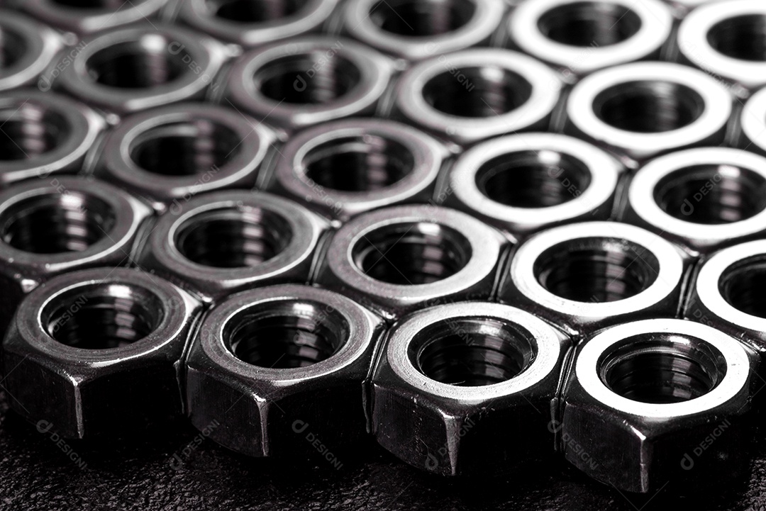 Porcas de aço metálicas colocadas em composição sobre um fundo preto