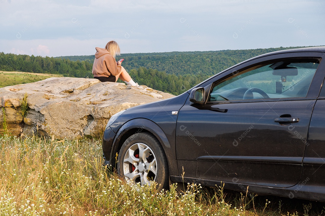 Mulher olhando linda paisagem sentada na pedra