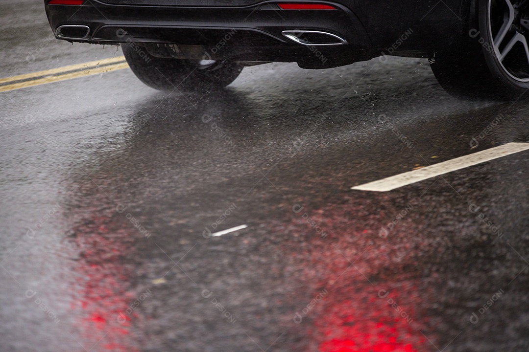 Carro em movimento em uma via com chuva