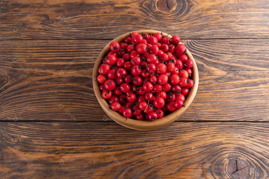 Crataegus sobre uma tigela em uma mesa de madeira