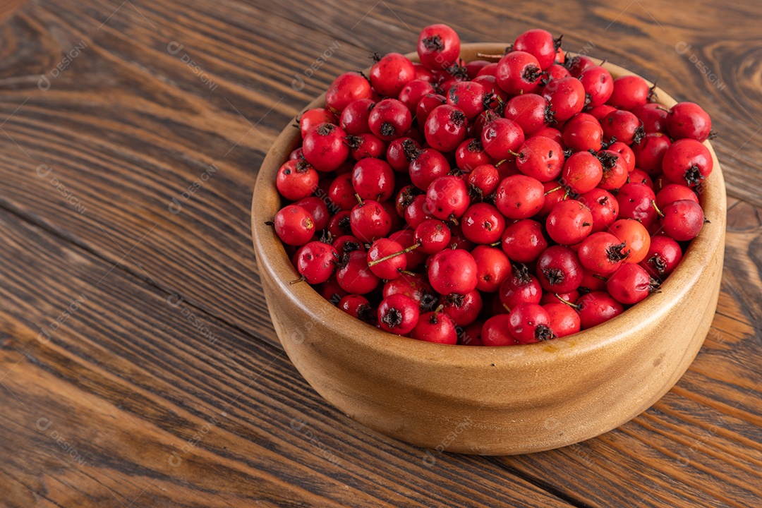 Crataegus sobre uma tigela em uma mesa de madeira