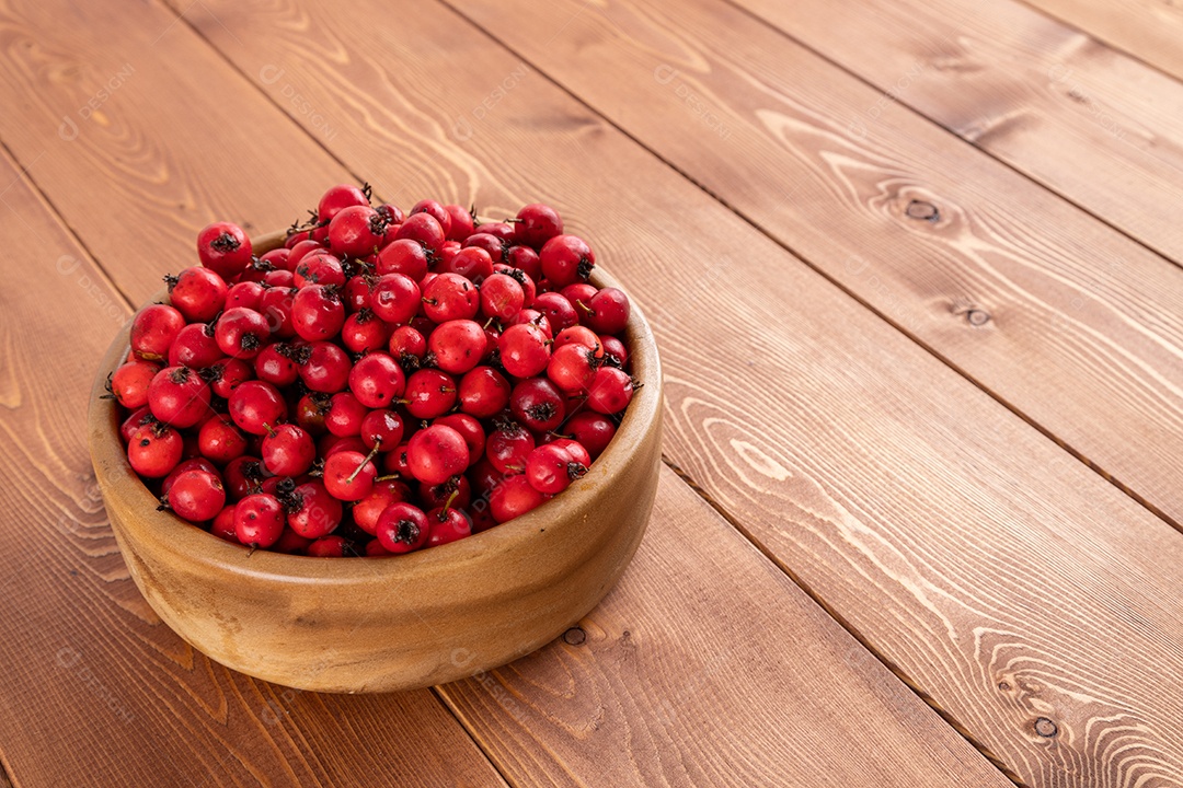 Crataegus sobre uma tigela em uma mesa de madeira