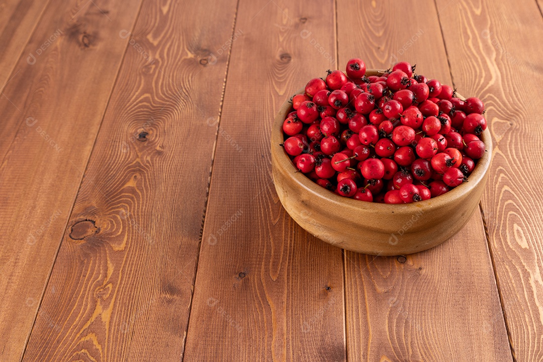 Crataegus sobre uma tigela em uma mesa de madeira