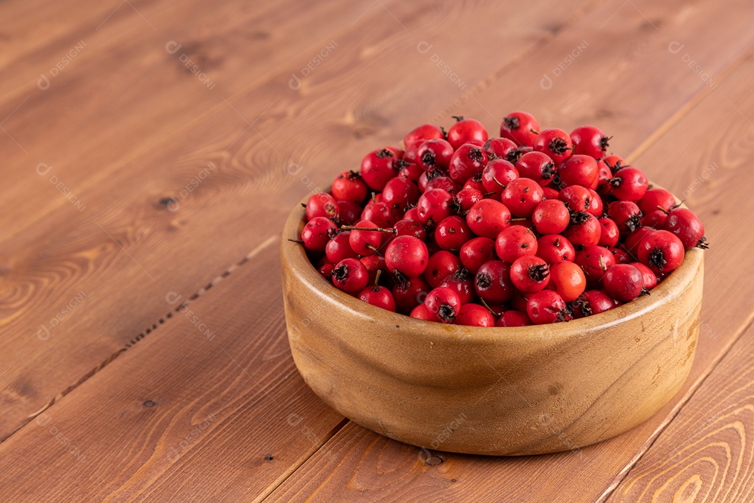 Crataegus sobre uma tigela em uma mesa de madeira