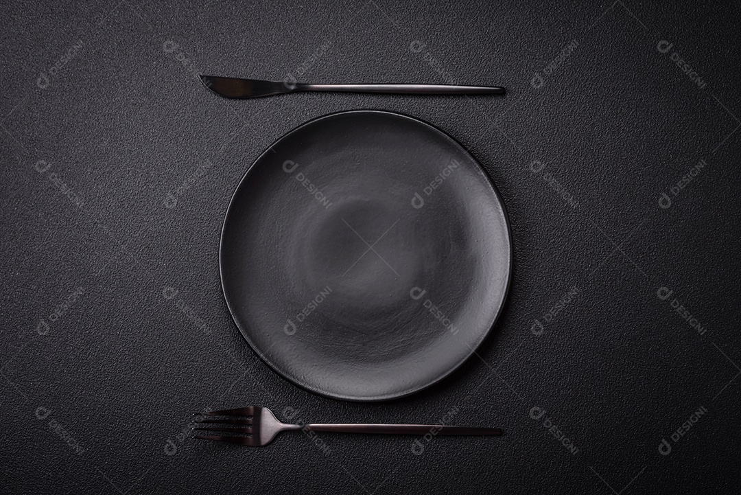 Placa cerâmica vazia e acidentada em um fundo de concreto texturizado. Utensílio de cozinha