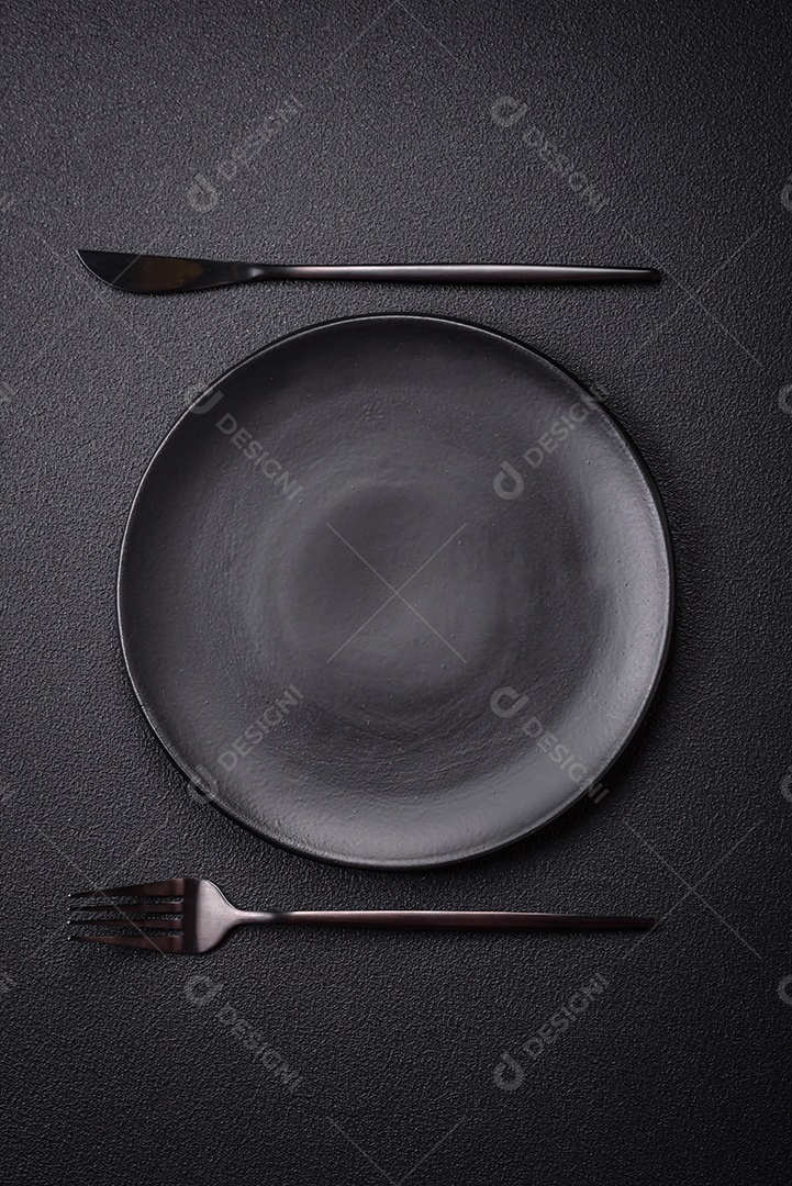 Placa cerâmica vazia e acidentada em um fundo de concreto texturizado. Utensílio de cozinha