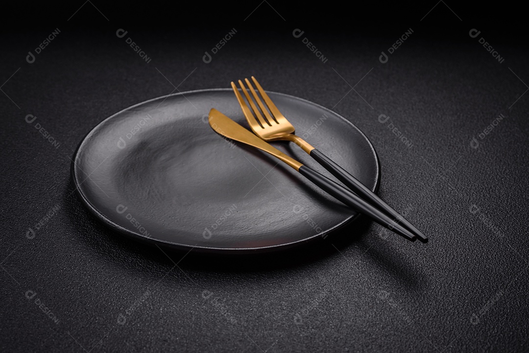 Placa cerâmica vazia e acidentada em um fundo de concreto texturizado. Utensílio de cozinha