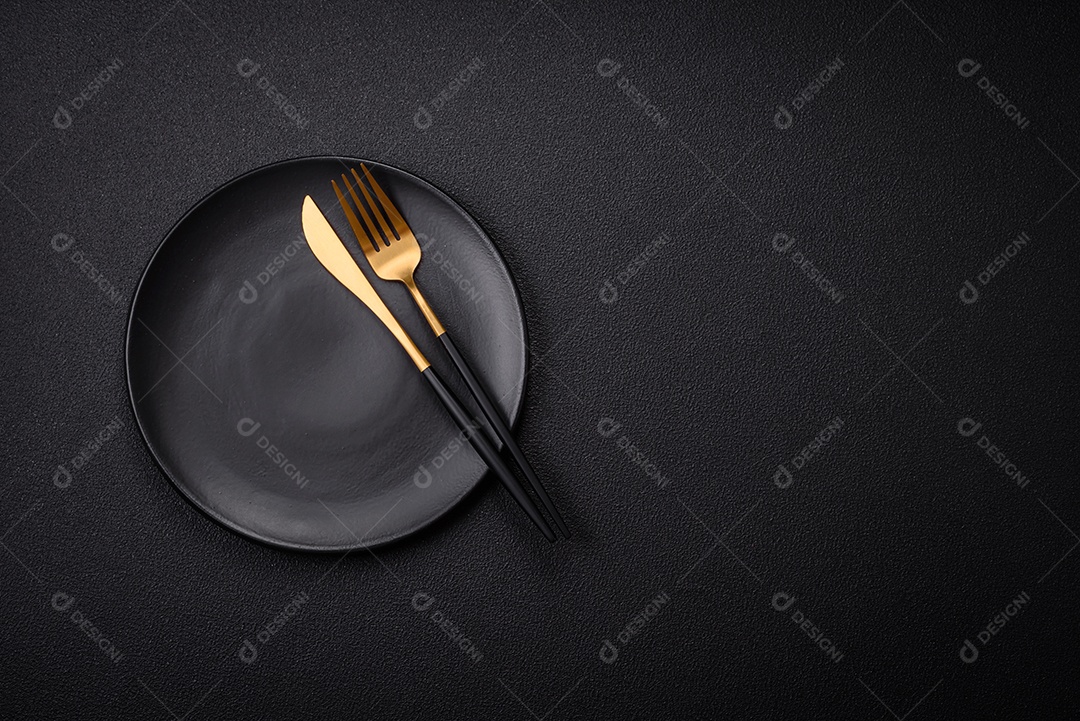 Placa cerâmica vazia e acidentada em um fundo de concreto texturizado. Utensílio de cozinha