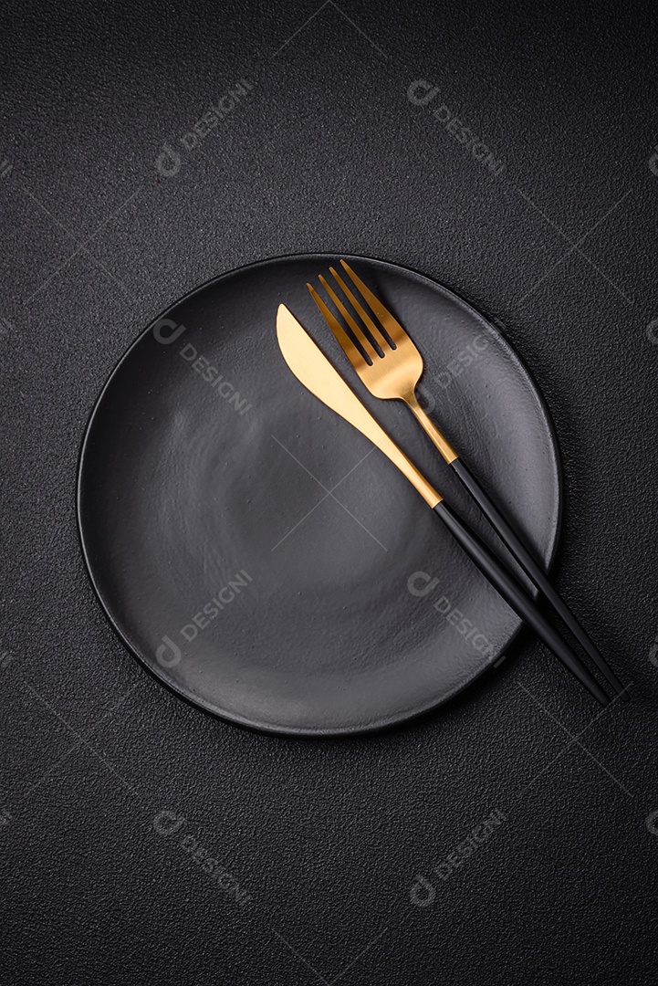 Placa cerâmica vazia e acidentada em um fundo de concreto texturizado. Utensílio de cozinha