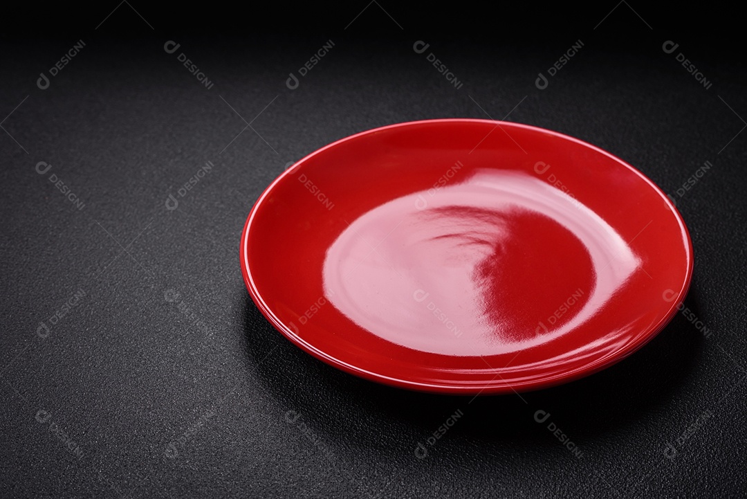 Placa cerâmica vazia e acidentada em um fundo de concreto texturizado. Utensílio de cozinha