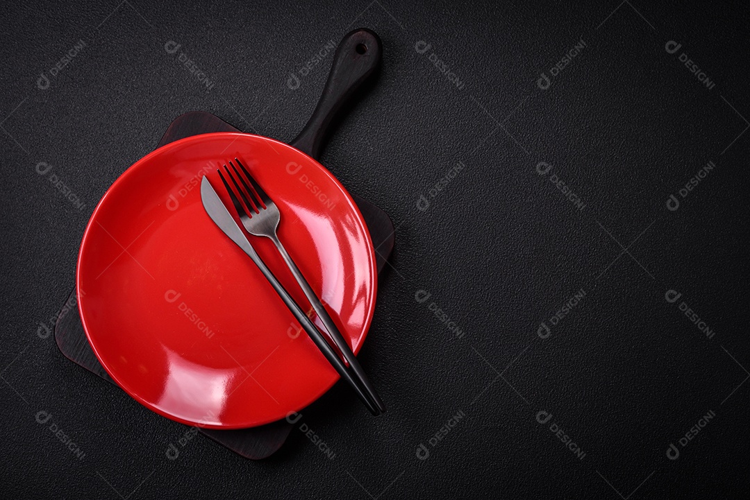 Placa cerâmica vazia e acidentada em um fundo de concreto texturizado. Utensílio de cozinha