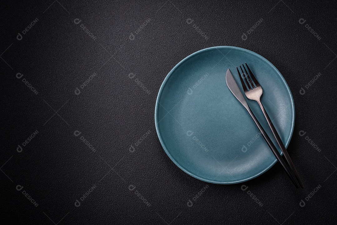 Placa cerâmica vazia e acidentada em um fundo de concreto texturizado. Utensílio de cozinha