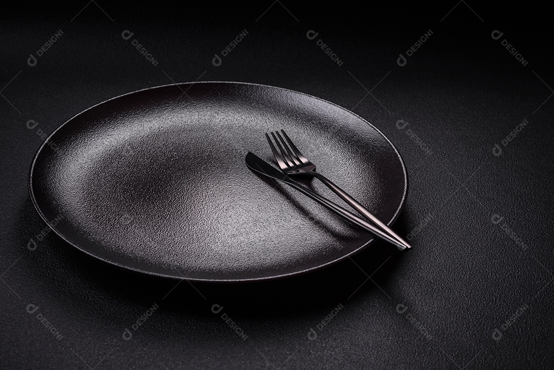 Placa cerâmica vazia e acidentada em um fundo de concreto texturizado. Utensílio de cozinha