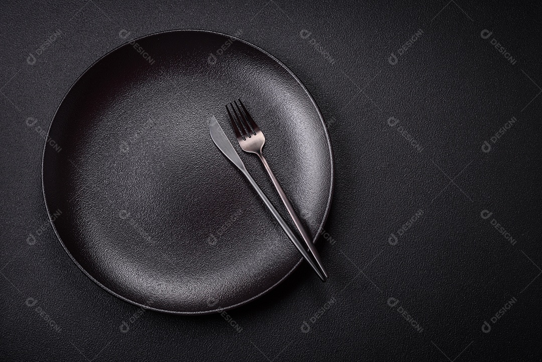 Placa cerâmica vazia e acidentada em um fundo de concreto texturizado. Utensílio de cozinha