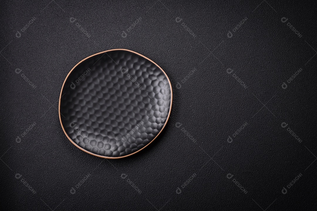 Placa cerâmica vazia e acidentada em um fundo de concreto texturizado. Utensílio de cozinha