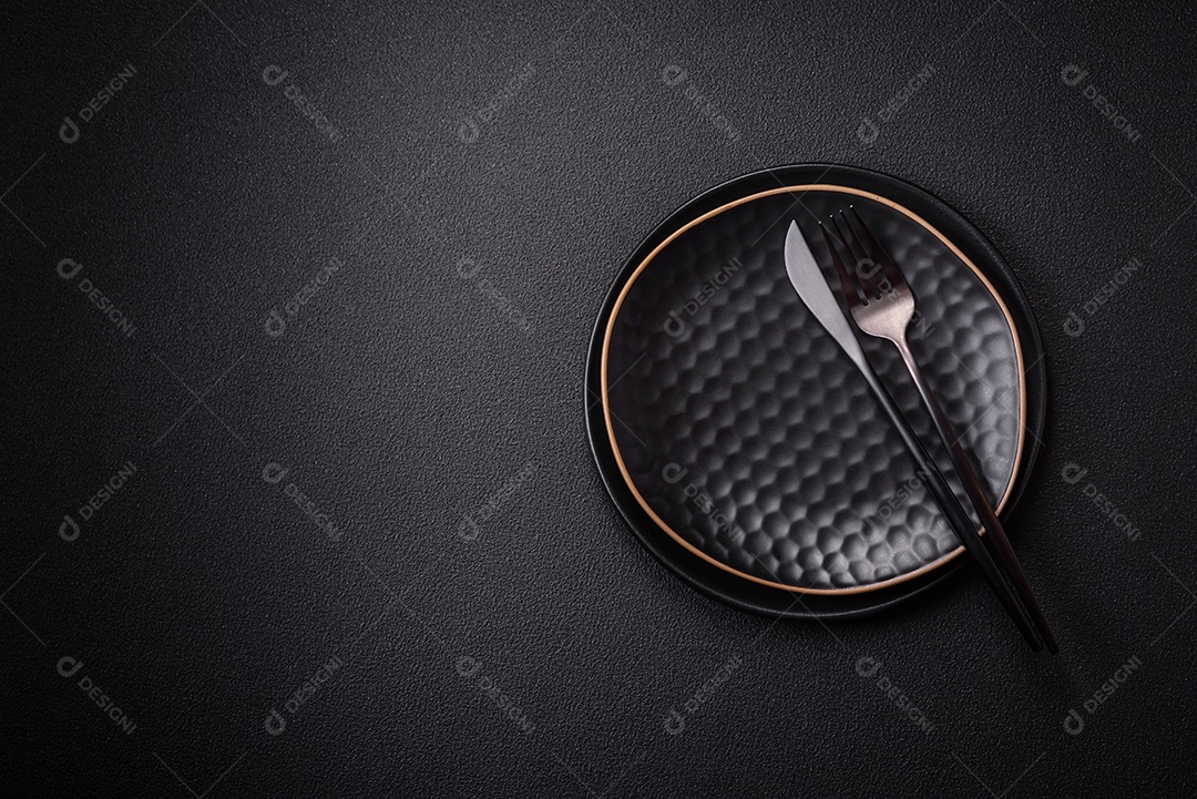 Placa cerâmica vazia e acidentada em um fundo de concreto texturizado. Utensílio de cozinha