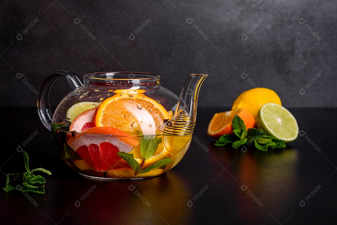 Chá de frutas quentes com limão, hortelã, laranja, limão e toranja em um lindo bule de vidro