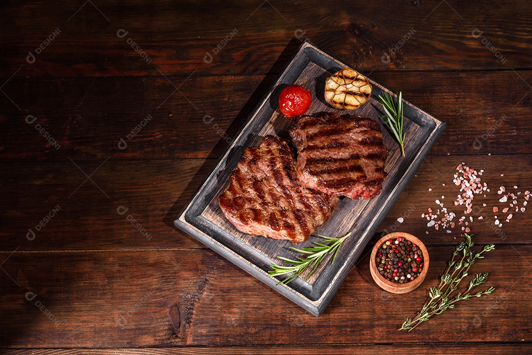 Bife fresco, suculento e delicioso em um fundo escuro. Prato de carne com especiarias e ervas