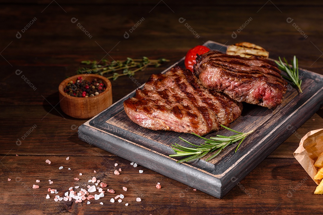 Bife fresco, suculento e delicioso em um fundo escuro. Prato de carne com especiarias e ervas