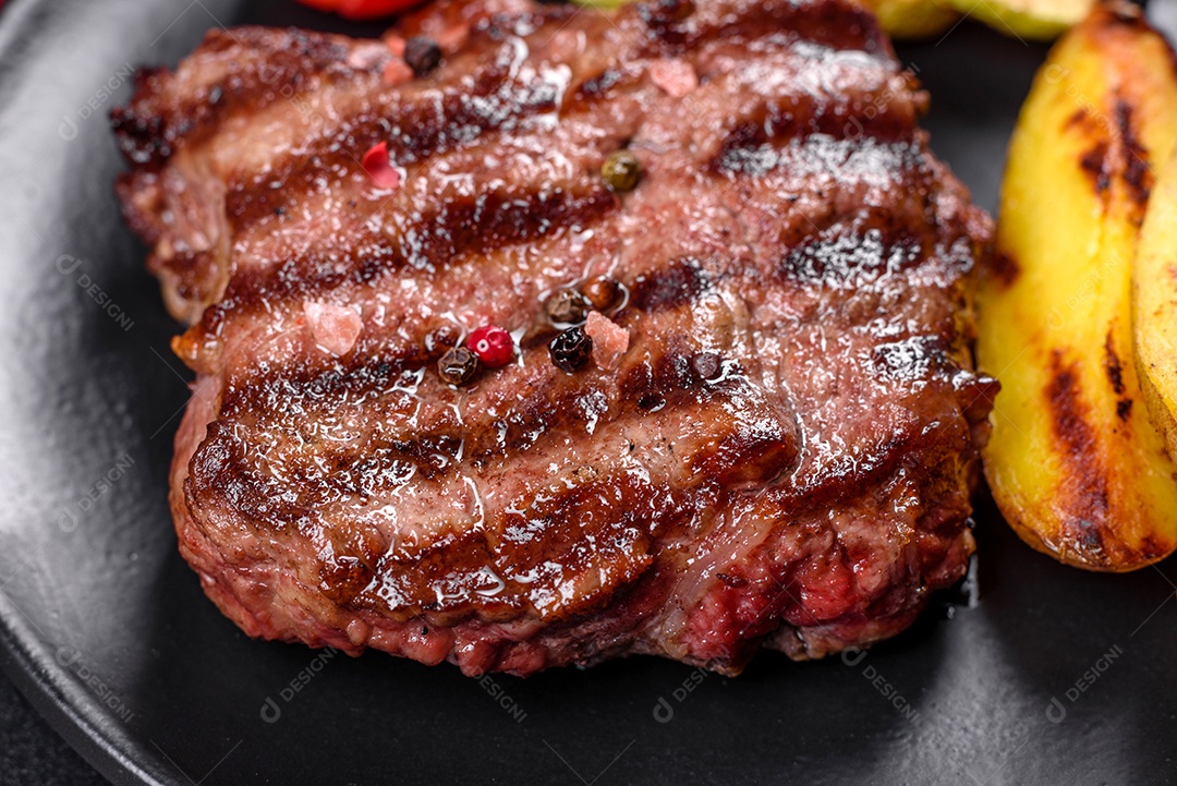 Bife fresco, suculento e delicioso em um fundo escuro. Prato de carne com especiarias e ervas